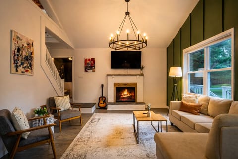 Relax in this spacious living room, complete with everything you need— a cozy fireplace, Smart TV, and comfortable seating, all framed by large windows that flood the space with natural sunlight.