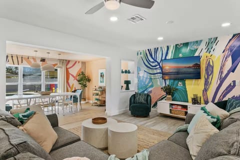 Open-concept living made for your whole crew: a colorful mural, big sectional and dining table in one bright space, so nobody is stuck in another room while dinner comes together.