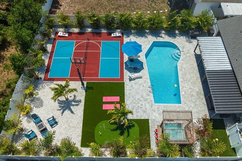 Backyard oasis featuring a pool, hot tub, basketball and pickleball court, firepit, and plenty of additional amenities for the ultimate stay and outdoor entertainment.