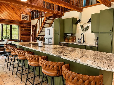 Open concept living with large center island with six bar stools. Well stocked kitchen with induction stove and dishwasher.