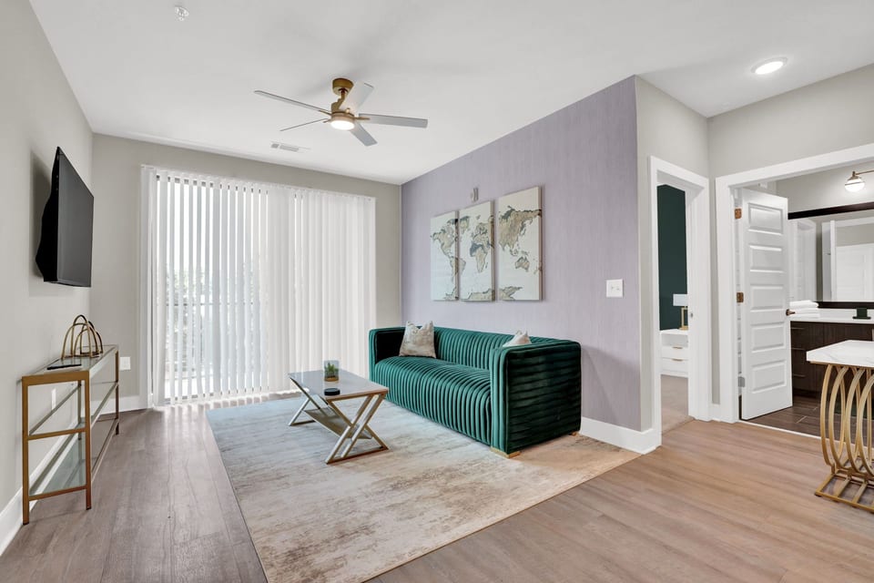 Bright and stylish living room with Smart TV, comfortable seating, and private balcony access.