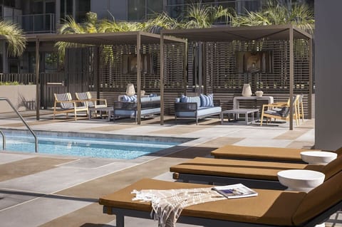 Shared pool deck with lounge chairs and shaded seating.