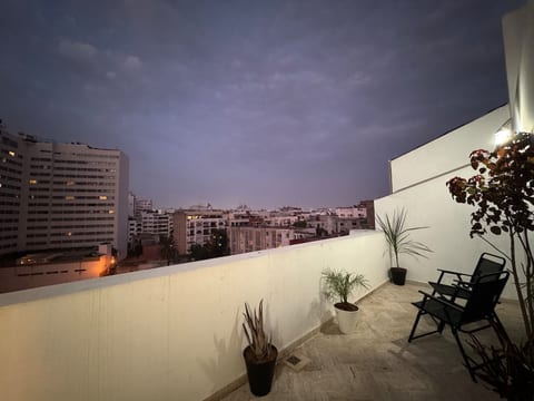 Stunning nighttime panoramic view of Casablanca’s illuminated skyline directly from the rooftop — palm trees, boulevards and city lights as far as the eye can see.