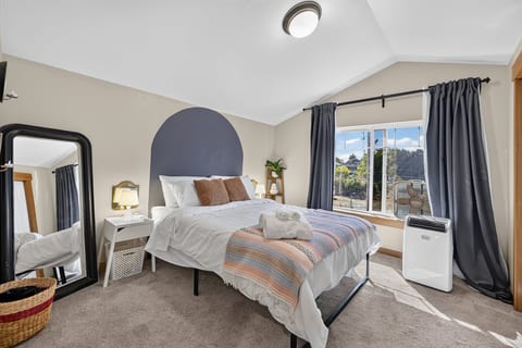Bright, cozy bedroom with large windows, soft linens, and natural light