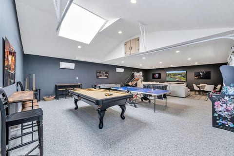 Spacious game room featuring pool table, ping pong, arcade games, Air Hockey, and basketball game. Bright, modern space with plenty of seating, perfect for friendly competition, family fun, and hours of entertainment for all ages. Sleep Sofa