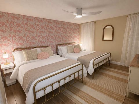 Guest bedroom with queen and full beds, hotel quality bedding, usb bedside lamps & nighstands, dresser, closet, ceiling fan and smart TV