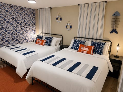 Guest bedroom with queen and full beds, hotel quality bedding, usb bedside lamps & nighstands, dresser, closet, ceiling fan and smart TV
