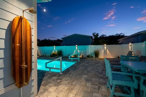 Resort-style private pool patio with outdoor shower and evening ambiance