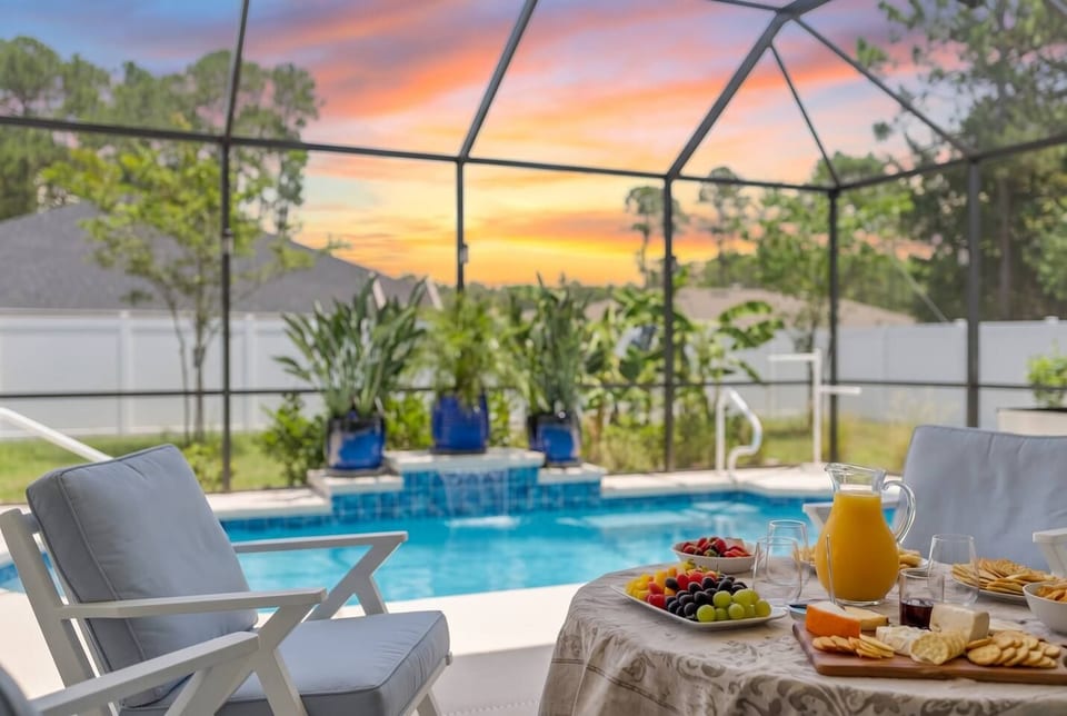Private screened saltwater heated pool with waterfall at golden hour — your Palm Coast vacation paradise at Salty Reef