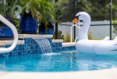 Resort-style saltwater pool waterfall with fun floaties — heated year-round, always included at Salty Reef Palm Coast Florida