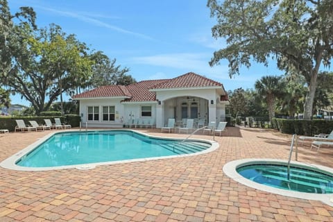 A stunning Mediterranean-style retreat with a sparkling pool and lush landscaping — this is what Florida living looks like.