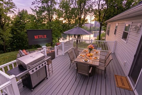 Waterfront deck with dining, grill, and outdoor movie nights at sunset