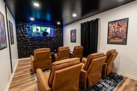 Private home theater with recliners, blackout curtains, and cinematic style