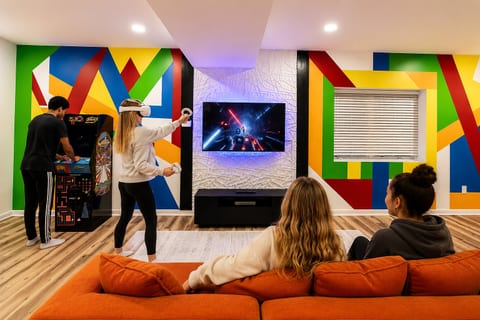 Colorful game room with VR, arcade fun, and cozy lounge seating