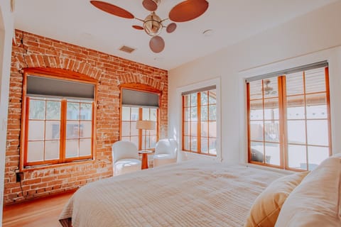 Master bedroom: king size bed, exposed brick, beautiful natural light.