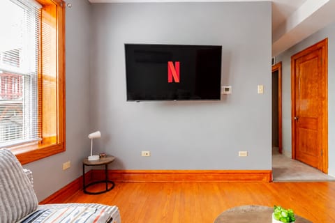 Bright living space with hardwood floors and wall-mounted streaming TV