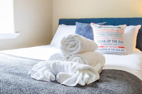 Bright, beachy bedroom with plush linens and spa-style towels