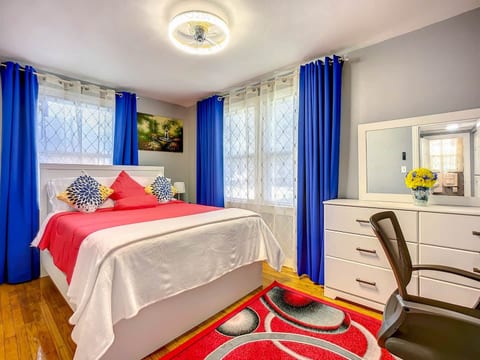 Bedroom 1 with queen size bed, blackout curtains. Noise machine, alarm clock, and bible in drawer