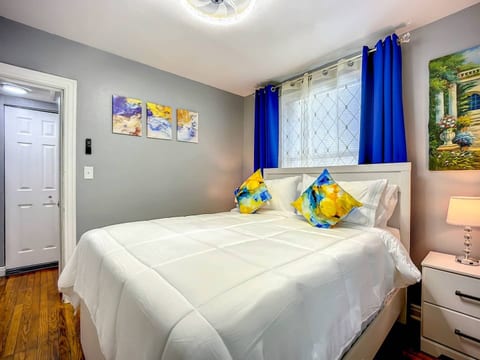 Bedroom 2 with queen sized bed, blackout curtains, noise machine, alarm clock, closet with iron and ironing board.
