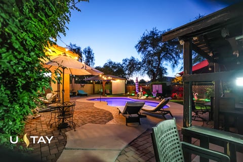 Inviting twilight pool patio with lounge seating and ambient string lights