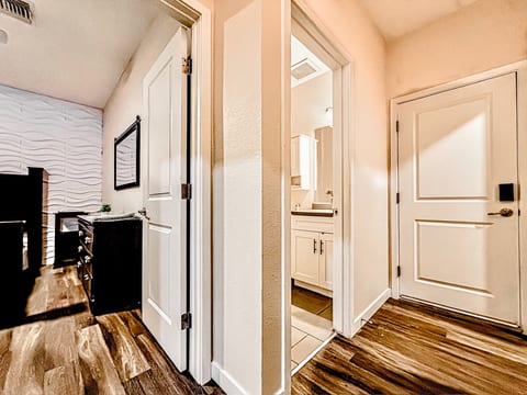 Modern entry with keyless lock, wood floors, bath, and 3D accent-wall room.