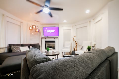 Bright living room with fireplace, smart TV, and plush sectional
