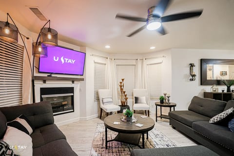 Modern lounge with fireplace, smart TV, and comfy seating for groups