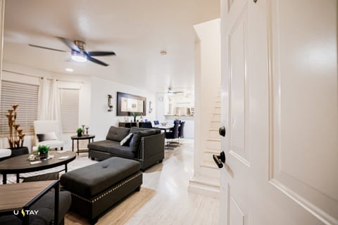 Bright open-plan living with dining table, breakfast bar, and cozy sofa