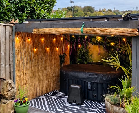 Private Hot Tub Retreat Enjoy a relaxing soak in your private, sheltered hot tub, surrounded by greenery, ambient lighting and cosy garden hideaway vibes.