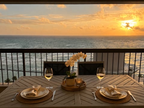 Private lanai, 171 sq ft, set for two as the sun drops behind Waikiki Beach.
