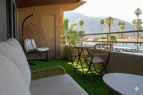 Mountain-view balcony with swing chair, bistro set, and turf lounge