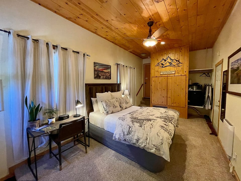 Guest room with queen bed, refrigerator, microwave, coffee/tea bar, and desk