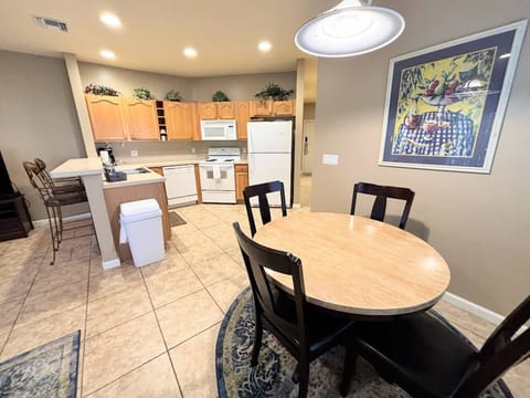 Spacious dining and kitchen area featuring a round dining table, breakfast bar seating, and full-size appliances.