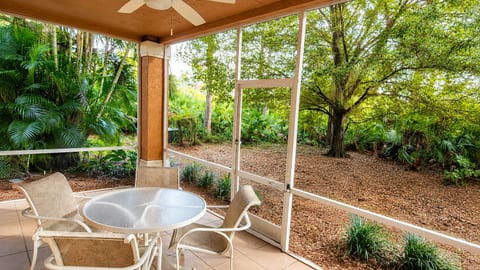 Private screened patio with outdoor seating and peaceful views of the surrounding landscaping.