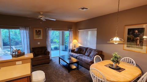 Comfortable living and dining area with cozy seating, ceiling fan, and access to the screened patio.