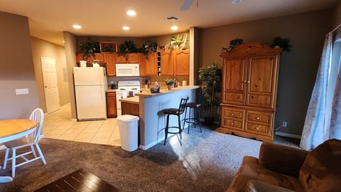 Open kitchen and living area with full-size appliances, breakfast bar seating, and a bright, functional layout.