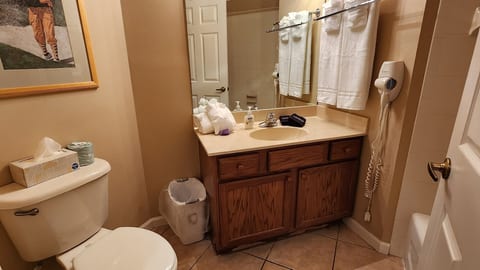 Clean bathroom with vanity storage, toilet, tile flooring, and neutral finishes.