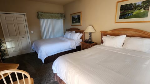 Comfortable bedroom with two beds, bedside lighting, dresser storage, and a bright, relaxing layout.