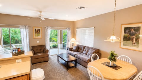 Comfortable living and dining area with cozy seating, ceiling fan, and direct access to the screened patio.