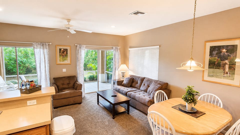 Comfortable living and dining area with cozy seating, ceiling fan, and direct access to the screened patio.