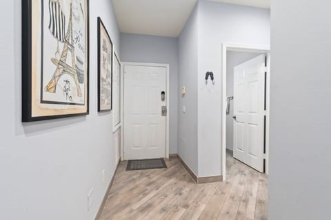Clean entry hallway with wood-look flooring, neutral finishes, and easy access to the main living areas and bedrooms.