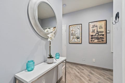 Welcoming hallway space with a decorative console table, mirror, and coastal-style artwork.