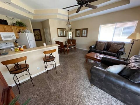 Comfortable living and dining area with cozy seating, breakfast bar seating, and large windows for natural light.