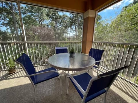 Private screened balcony with outdoor seating and peaceful views of the surrounding greenery.