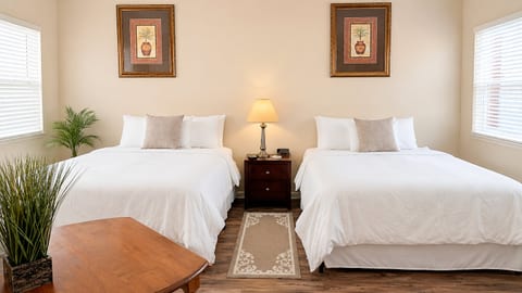 Comfortable bedroom with two beds, bedside table, small seating area, and a bright, relaxing layout.
