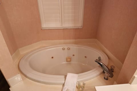 Bathroom featuring a soaking tub, tile surround, and bright natural light from the window.