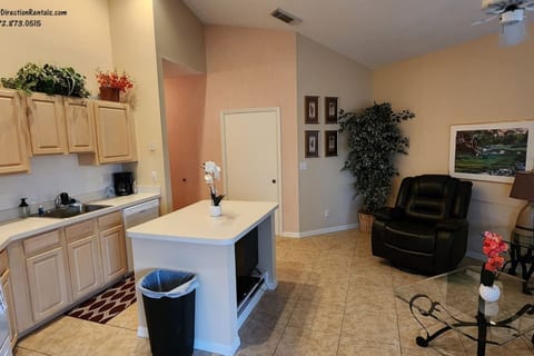 Spacious kitchen and living area featuring vaulted ceilings, plenty of cabinet storage, breakfast bar seating, and comfortable seating.
