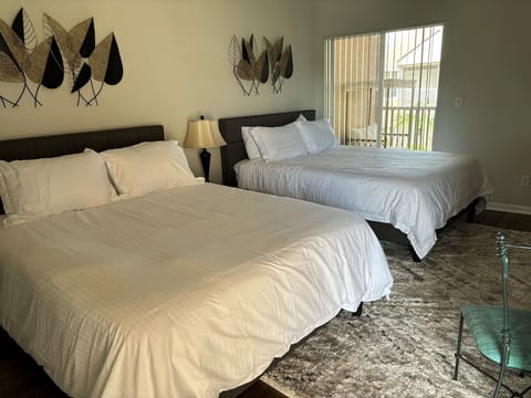 Comfortable bedroom with two beds, natural light, and easy access to the outdoor balcony area.