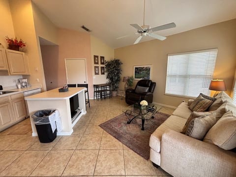 Bright living and kitchen area with vaulted ceilings, comfortable seating, and a relaxed open layout.