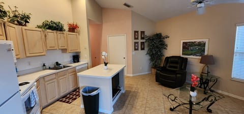 Open kitchen and living space featuring full-size appliances, breakfast bar seating, and a comfortable sitting area.